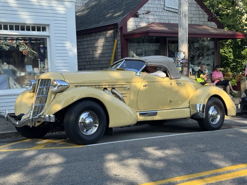 Cream Auburn Boattail Speedster on a sunlit street